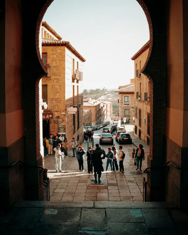 An old-town street seen through a stone archway