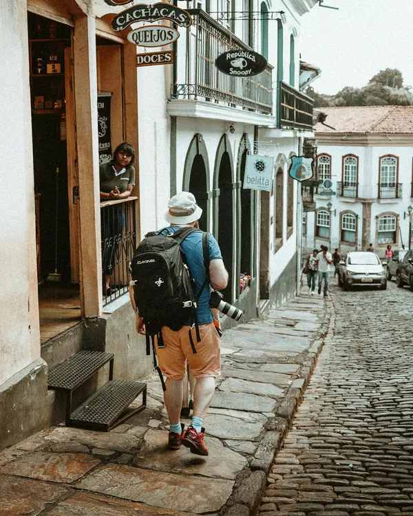 A traveller with a backpack walking a cobbled old-town street